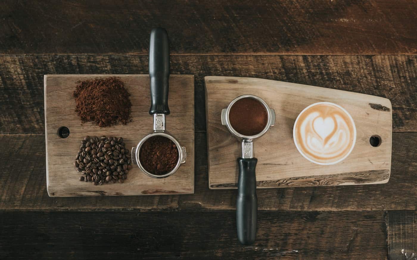 A burr grinder beside freshly ground coffee on a kitchen counter