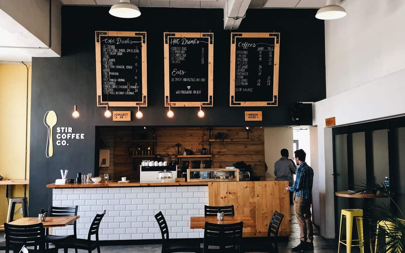 A warm cafe counter with an espresso machine, lit for the evening