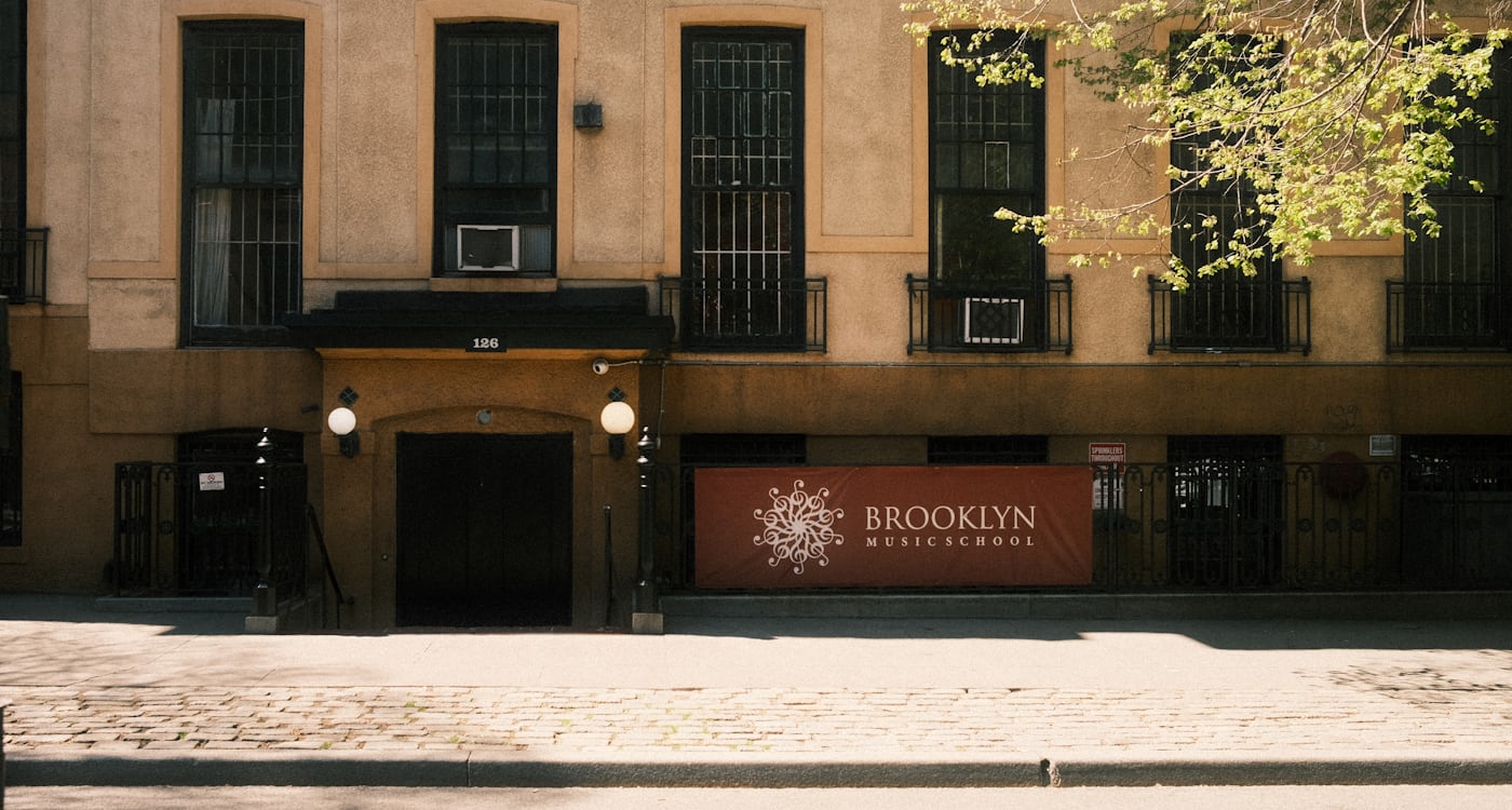 Brownstone storefronts on a tree-lined street in a central Brooklyn neighborhood